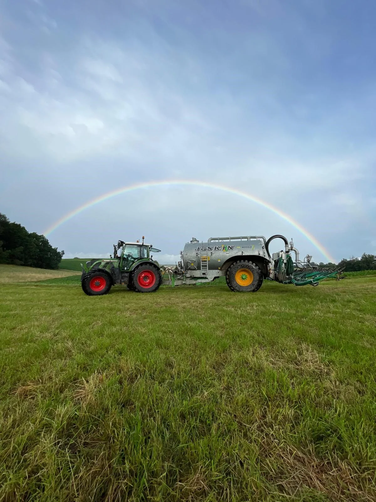 Traktor mit Güllefass auf dem Grünland