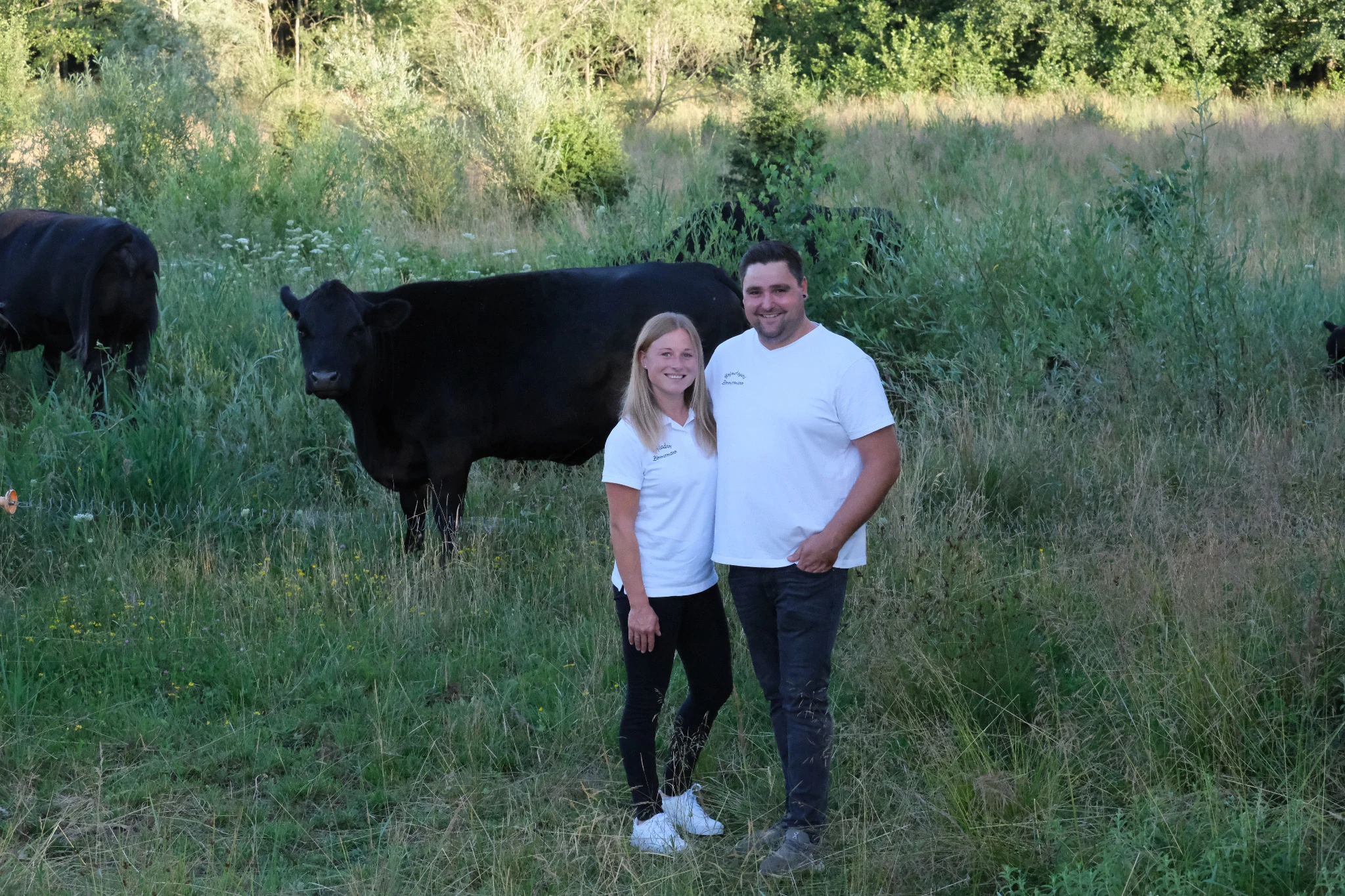 Lena und Martin Zimmermann mit ihren Rindern auf der Weide